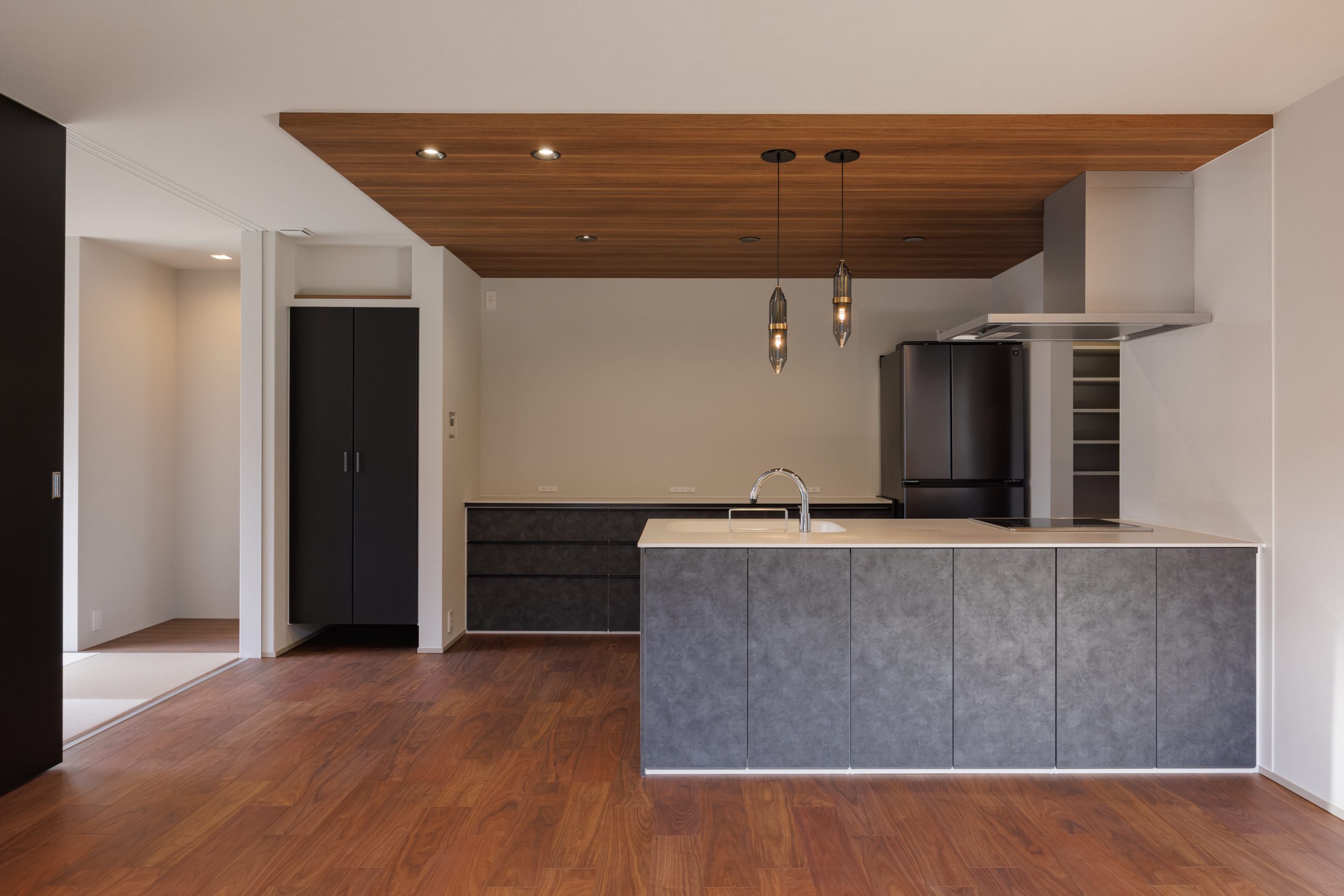 人気の石目調キッチンを採用。下がり天井で空間を仕切るハイセンスなLDK